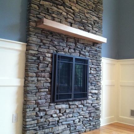 Gas fireplace with custom stone work, oak mantle and wainscoting